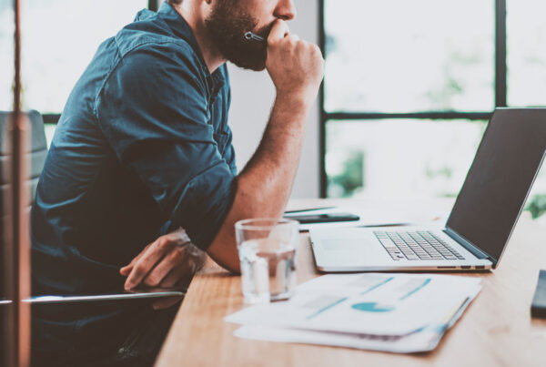 Committee members reviewing a Queensland building contractor’s QBCC licence, insurance details, and written construction contract before signing